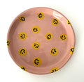 Handmade ceramic plate with pink background and yellow smileys