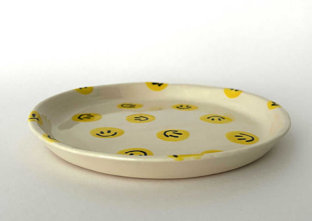 Handgemaakt keramieken bord met smileys in verschillende kleurvariaties