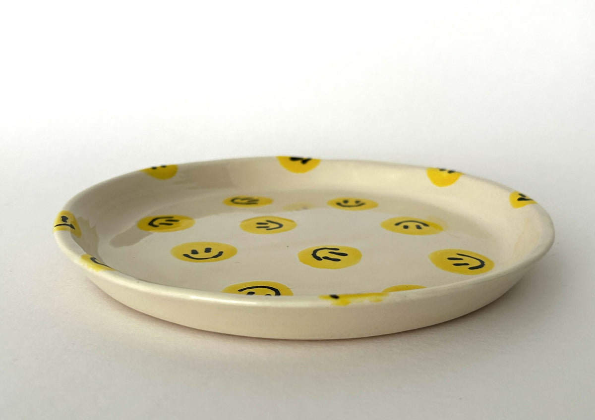 Handgemaakt keramieken bord met smileys in verschillende kleurvariaties