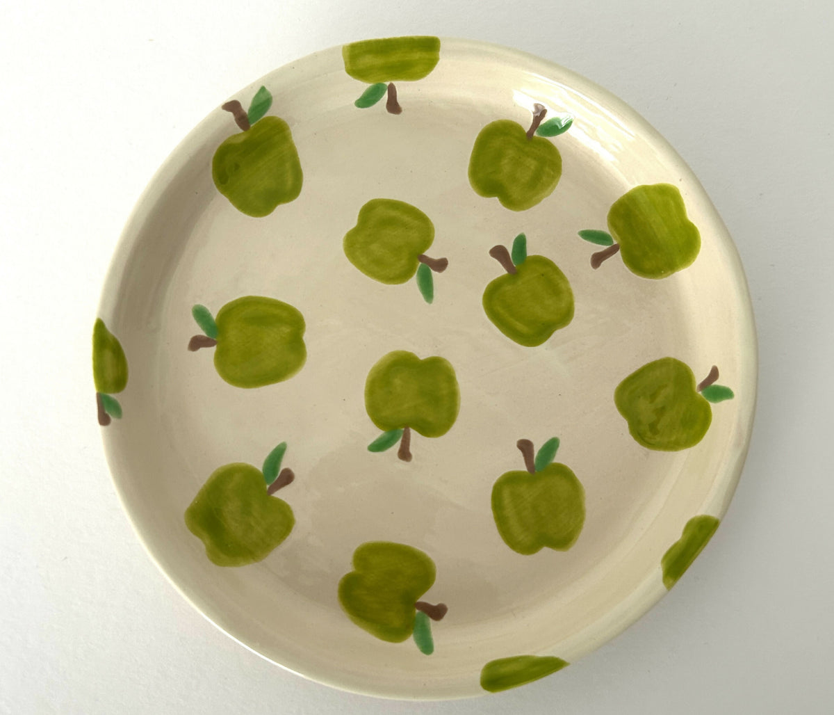 Handgemaakt keramisch bord met groene appels