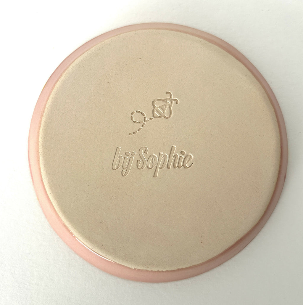 Handmade ceramic plate with pink background and yellow smileys